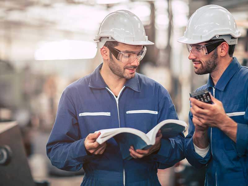 Workers consulting a manual